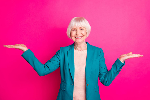 Portrait of her she nice-looking attractive lovely cheerful cheery confident gray-haired lady holding invisible objects on palms isolated over bright vivid shine vibrant pink fuchsia color background - Foto, Bild