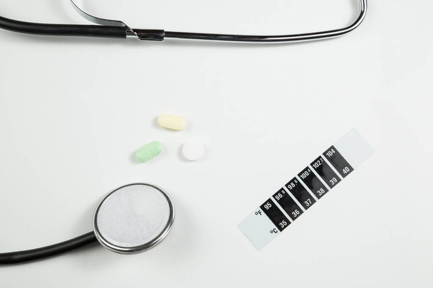 medische stethoscoop, medicatie en thermometer-strip op wit i - Foto, afbeelding