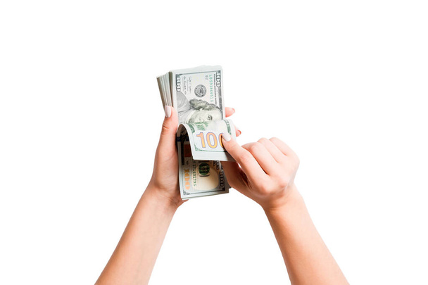isoliertes Bild weiblicher Hände, die Dollars auf weißem Hintergrund zählen. Gehalts- und Gehaltskonzept von oben - Foto, Bild