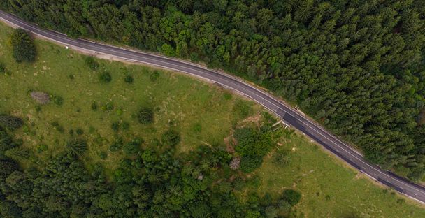 Aerial view over mountain road going through forest landscape. T - Fotoğraf, Görsel