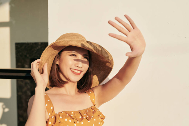 Портрет прекрасної азіатської дівчини, що покриває обличчя від руки яскравого сонячного світла, щасливої літньої відпустки. - Фото, зображення