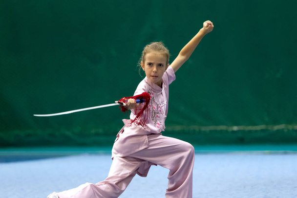 ODESSA, UKRAINE - October 1, 2019: Wushu athlete during the Wushu competition among children. Young athletes in competitions perform Chinese martial arts called Shaolin Kung Fu (Shaolin Wushu) - Foto, Bild