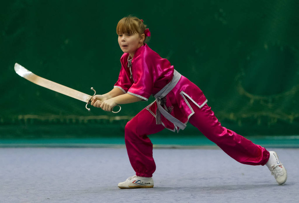 ODESSA, UKRAINE - October 1, 2019: Wushu athlete during the Wushu competition among children. Young athletes in competitions perform Chinese martial arts called Shaolin Kung Fu (Shaolin Wushu) - 写真・画像