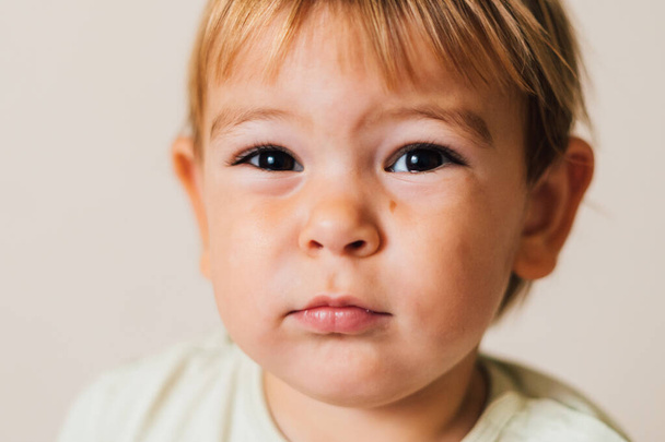 Küçük kız şüpheli ve şüpheci görünüyor. Kızgın bir bebeğin portresi. Boşluğu kopyala - Fotoğraf, Görsel