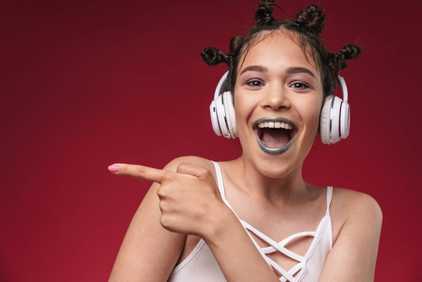 Image of excited punk girl with bizarre hairstyle pointing finge - Foto, Imagen
