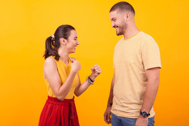 Smiling and beautiful girlfriend keeping her fists up in front of her boyfriend - Photo, Image