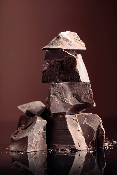 Pieces of dark chocolate on a dark background.  - Photo, Image