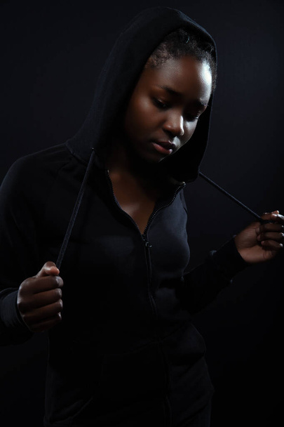 Холодная и застенчивая женщина с темной кожей и поведением в капюшоне - Фото, изображение