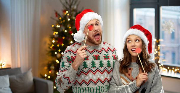 couple with christmas party props in ugly sweaters - Foto, Bild