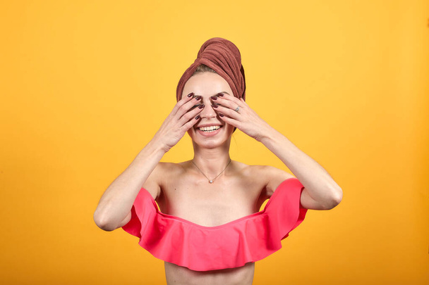 Nuori tyttö pyyhe päänsä yli eristetty oranssi tausta osoittaa tunteita
 - Valokuva, kuva