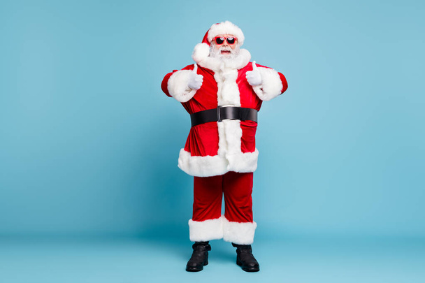 Full length body size view of his he nice cool cheerful glad fat bearded Santa wearing warm winter coat look outfit showing two double thumbup isolated over blue turquoise pastel color background - Fotoğraf, Görsel