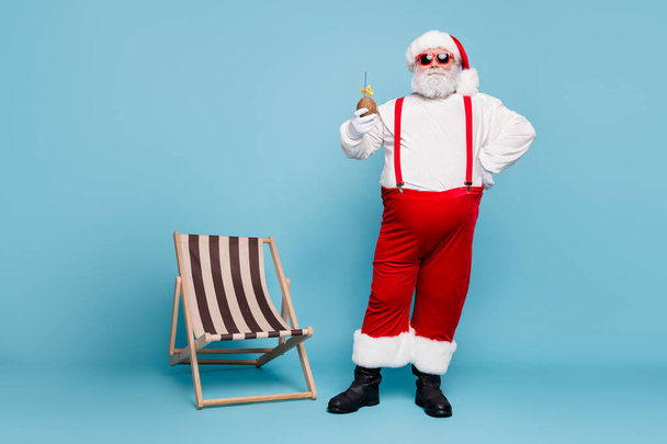 Full length body size view of his he nice confident cheerful cheery fat bearded Santa drinking coconut juice hotel spa resort isolated over blue turquoise pastel color background - Фото, зображення