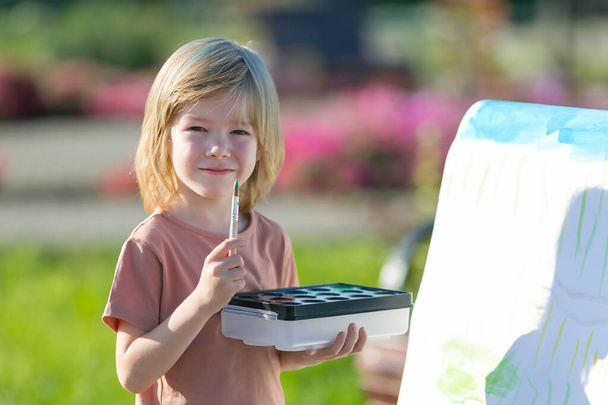 A preschool boy draws with paints. - Fotó, kép