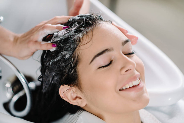 stylist Lavare i capelli del cliente nel salone di parrucchiere
  - Foto, immagini