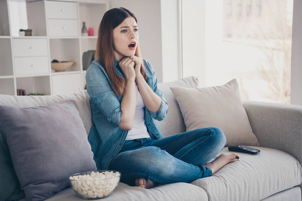 Photo of amazing lady watching long waited final episode of melodrama crying of lovers end sitting comfy sofa wearing jeans clothes apartment indoors - Foto, immagini