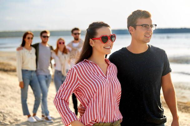 happy friends walking along summer beach - Fotografie, Obrázek