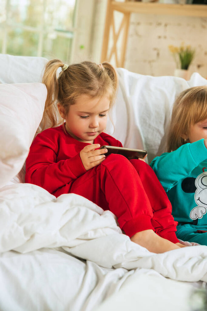 Little girls in soft warm pajamas playing at home - Valokuva, kuva