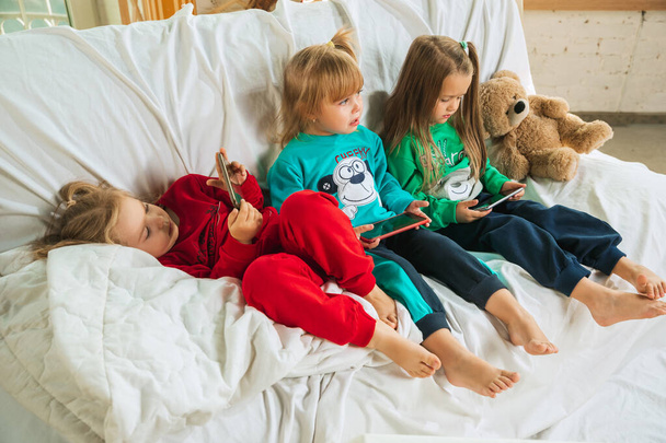 Little girls in soft warm pajamas playing at home - Zdjęcie, obraz