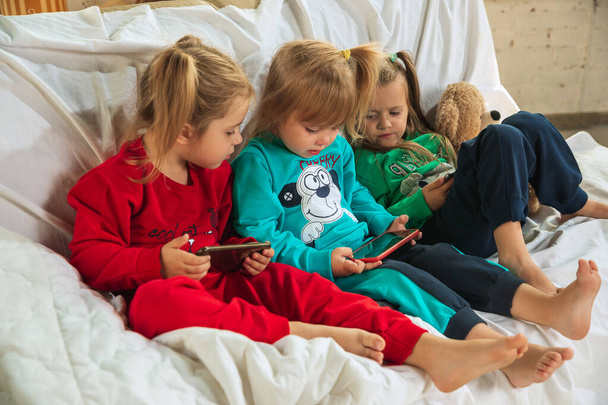 Little girls in soft warm pajamas playing at home - Photo, image