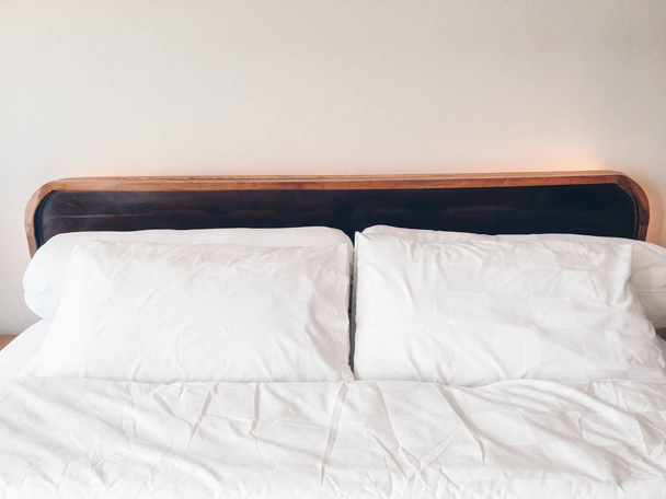 empty bed with white bedding in cozy bedroom - Fotoğraf, Görsel