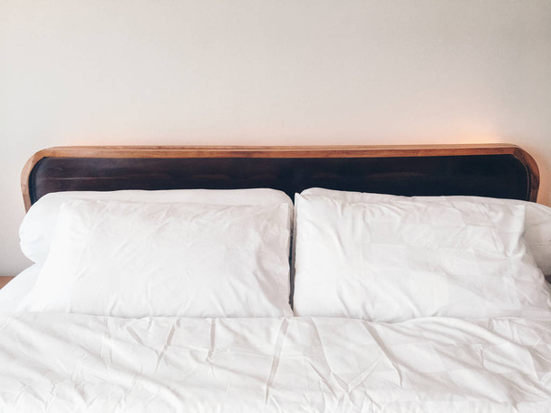 empty bed with white bedding in cozy bedroom - Φωτογραφία, εικόνα