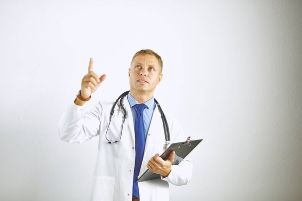 Junger selbstbewusster Arzt im weißen Kittel mit Stethoskop - Foto, Bild