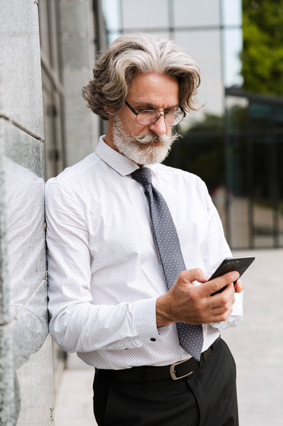 Attractive mature businessman wearing suit walking - Foto, immagini