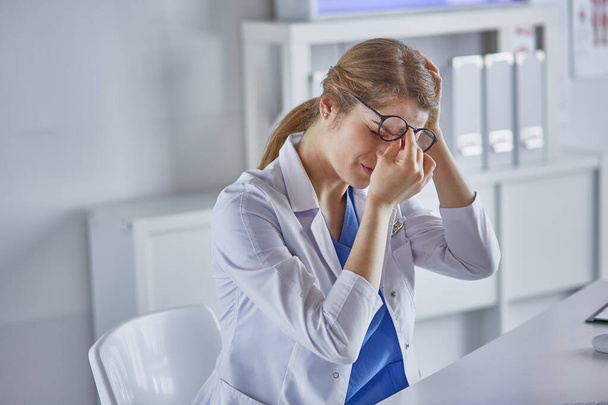 Молодая женщина-врач устала после работы с компьютером
 - Фото, изображение