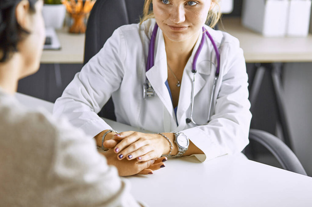 Kobieta lekarz uspokaja pacjenta i trzyma rękę - Zdjęcie, obraz