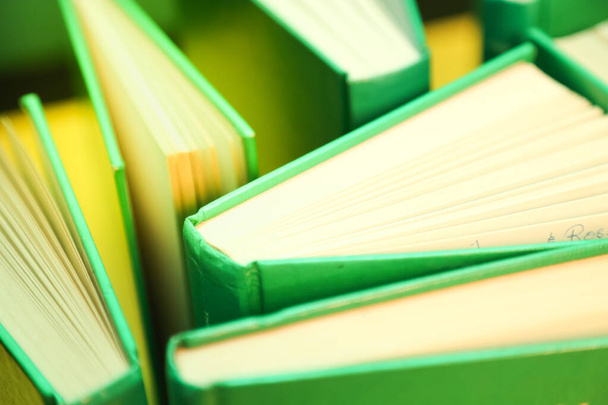grüne Bücher auf gelbem Hintergrund - offene Seiten  - Foto, Bild