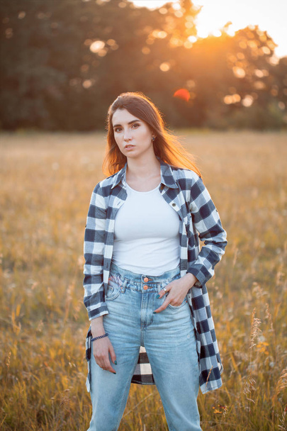 Young woman posing on the field at sunset - Foto, Imagen