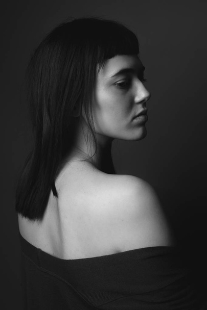 Portrait of attractive young woman with bare shoulders. Black and white. From back - Foto, Imagen