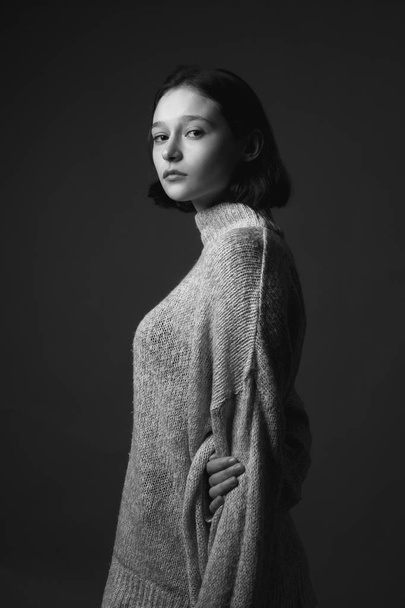 Portrait of beautiful thin young woman in sweater. Black and white - Foto, afbeelding