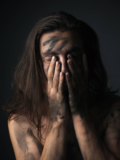 Портрет несчастного молодого человека с грязной кожей. Руки на лицо
 - Фото, изображение