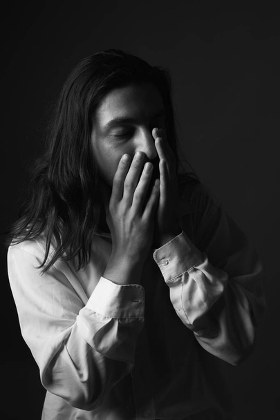 Sad young man with long hair. Black and white. - Фото, изображение