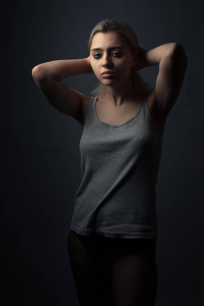 Portrait of sad young woman with smeared make up in tights and shirt. - Foto, imagen