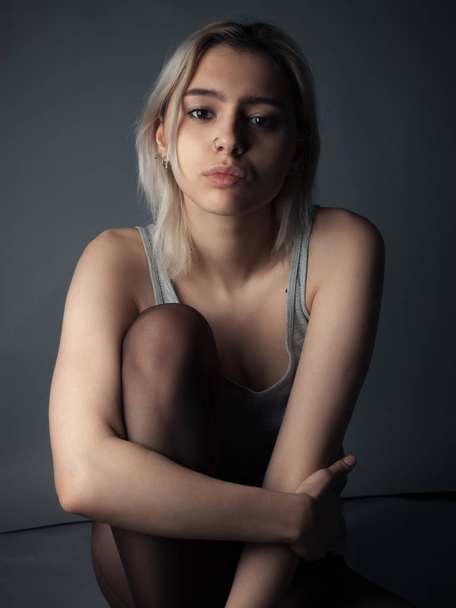 Sad girl in tights and shirt sitting on the floor - Photo, Image