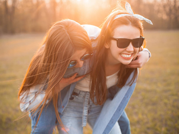 Two girls having fun outdoors at sunset. Best friends - Zdjęcie, obraz