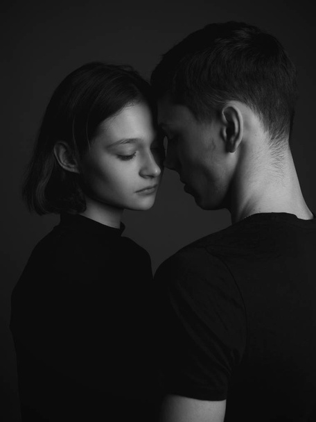Young couple posing in studio. Low key. Black and white - Zdjęcie, obraz