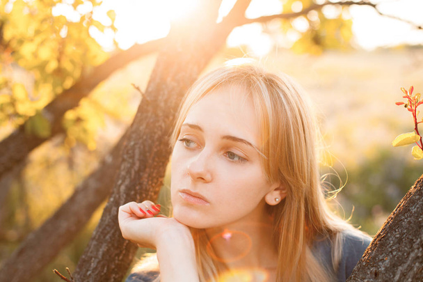 Portrait of beautiful young woman near the tree outdoors - Foto, Imagem