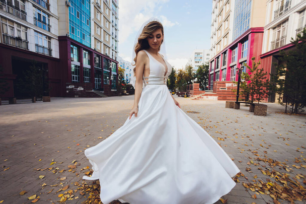 bride posing in a green park girl in a white dress on a background of green. - Zdjęcie, obraz
