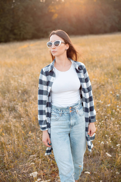 Young woman in sunglasses walking outdoors - Foto, afbeelding
