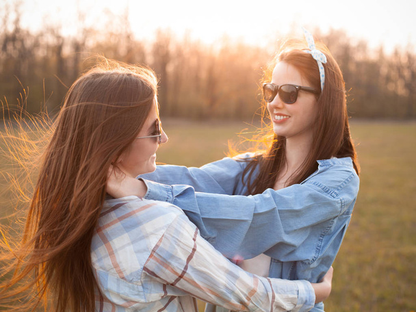 Two young women dancing outdoors. Best friends - Photo, image