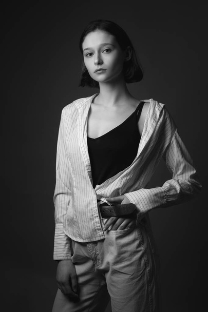Young beautiful woman in shirt posing in studio. Black and white - Foto, imagen