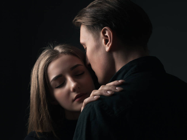 Young man and woman kissing in studio. Low key - Fotoğraf, Görsel