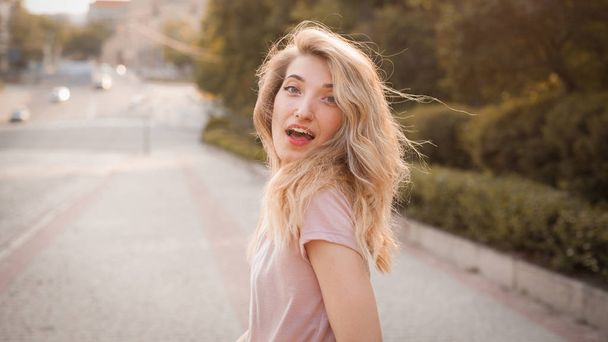 Young happy woman with beautiful hair walking on the street. - Photo, Image