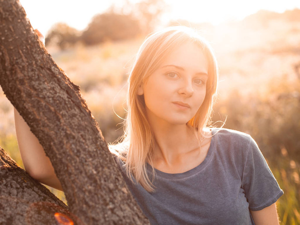 Portrait of young blonde woman outdoors under sunlight - Photo, Image
