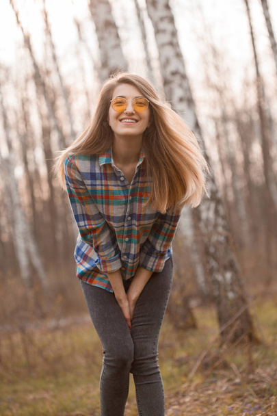 Happy young woman walking in a birch grove in autumn - Zdjęcie, obraz