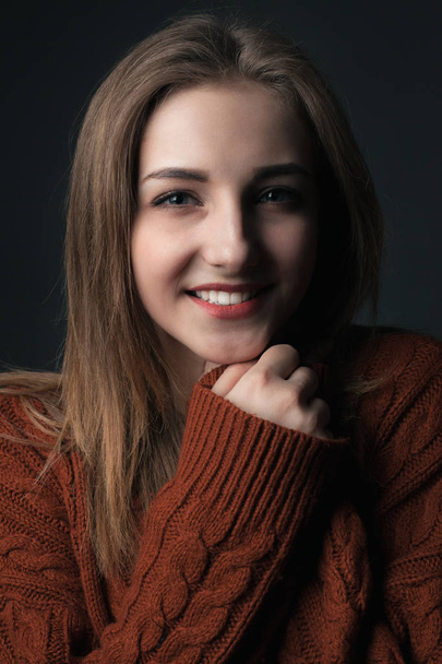 Portrait of smiling young woman in red sweater. - Фото, изображение
