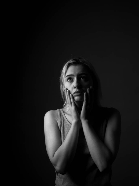 Portrait of sad girl in studio. Black and white. Low key - Foto, Imagen